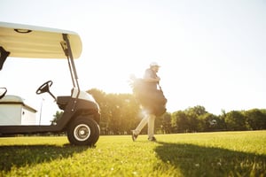 male-golfer-walking-with-golf-bag